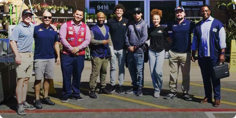 Cyberdyne employees standing in front of Lowe’s Home Improvement smiling and celebrating after closing a partnership deal.