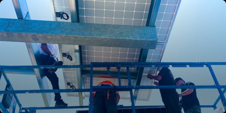 Two men engaged in the installation of a solar panel on a rooftop, highlighting advancements in green technology in Southern California.