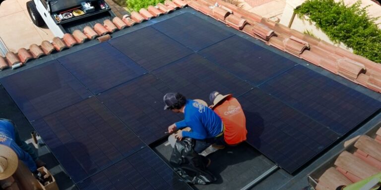 Cyberdyne employees involved in the process of installing a solar panel on a roof, emphasizing the significance of renewable energy initiatives.